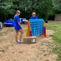 Two dental team members playing large outdoor connect four game