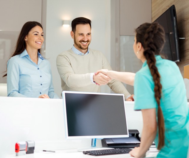 Young couple at dental front desk 